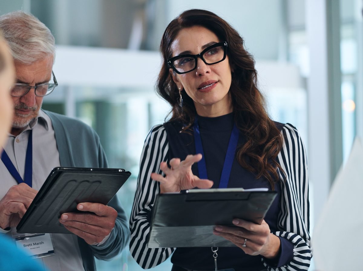 A market researcher discussing findings with tablets in hand during a client meeting